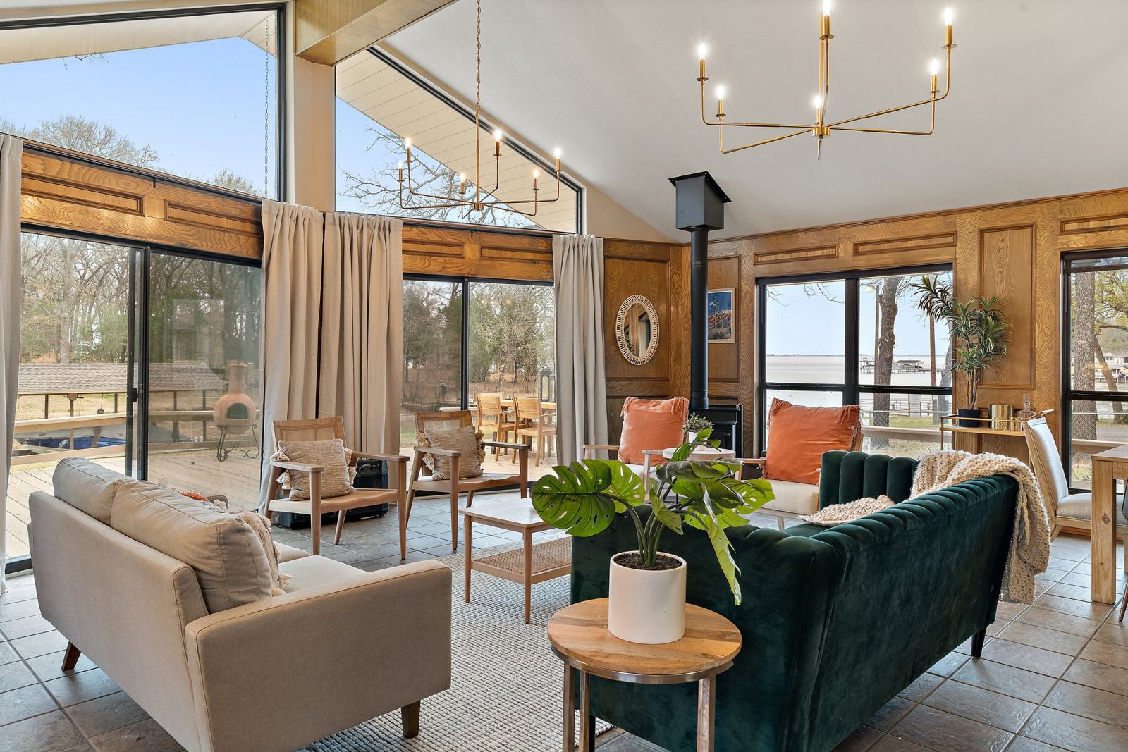 Living room with a green velvet sofa and windows looking out to Cedar Creek Lake